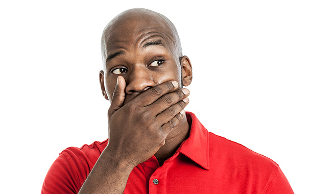 A man holding his mouth in pain.