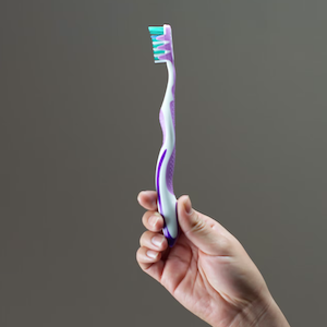 Hand Holding Toothbrush